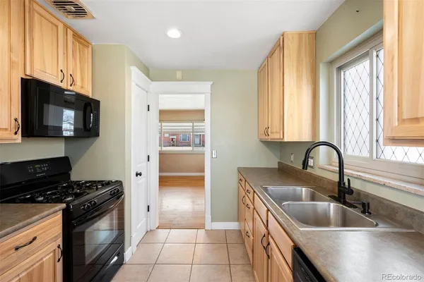 a kitchen with granite countertop a sink stainless steel appliances and cabinets