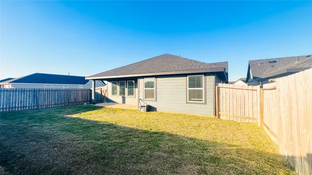 a view of a house with pool and wooden fence