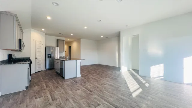 a kitchen with a refrigerator and a stove top oven