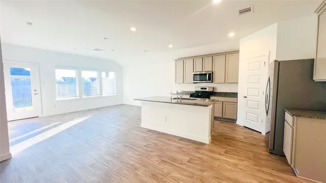 a kitchen with granite countertop white cabinets and stainless steel appliances