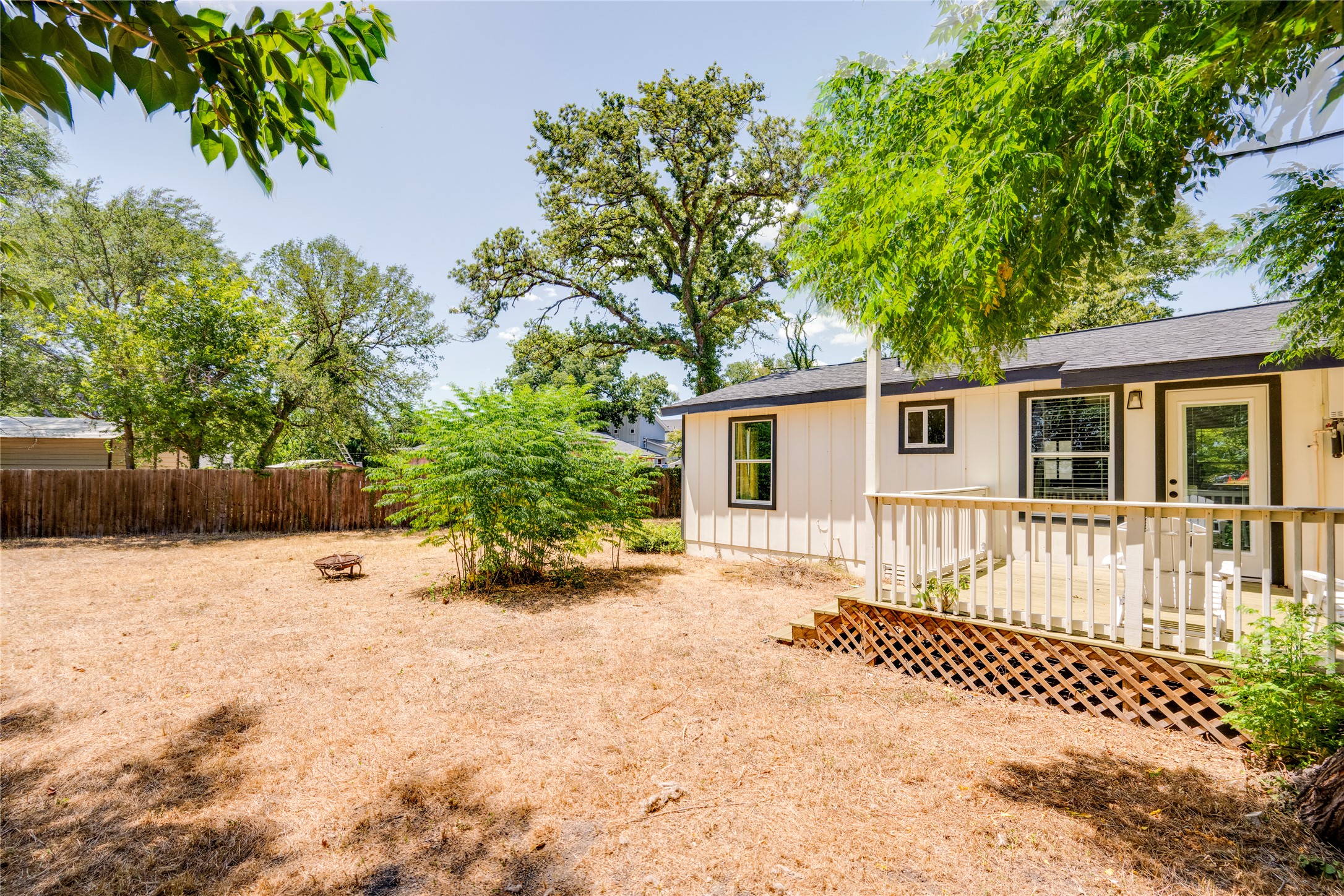 1400 Marcus Place, Unit B Austin, TX 78721 - Photo 33 of 39 A spacious yard with mature trees offers a serene backdrop for outdoor relaxation.