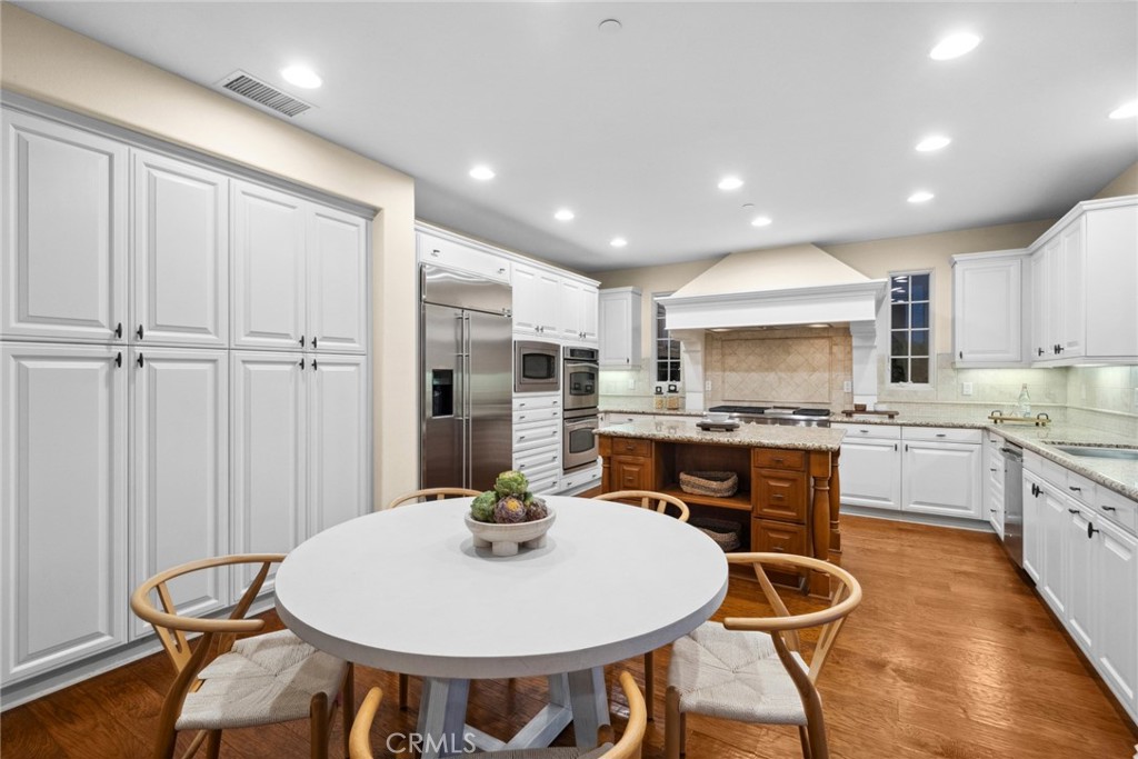 46 Silhouette Irvine, CA 92603 - Photo 6 of 42 a kitchen with stainless steel appliances kitchen island granite countertop a sink a stove a dining table and chairs