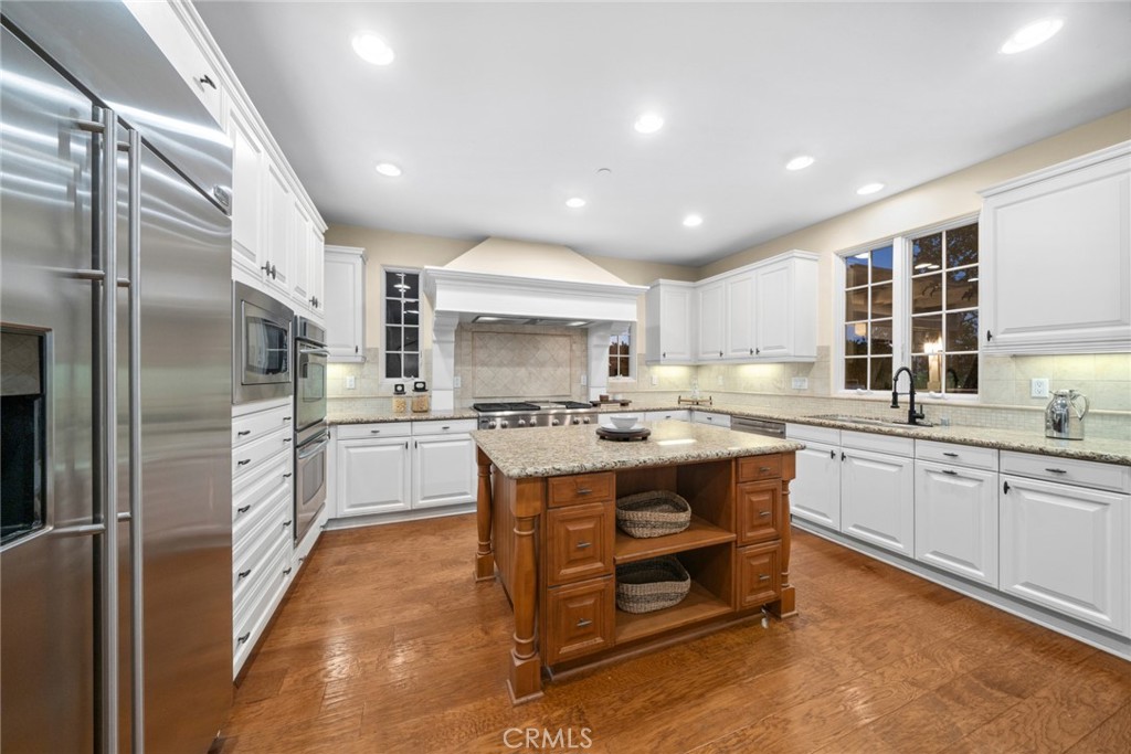 46 Silhouette Irvine, CA 92603 - Photo 8 of 42 a kitchen with kitchen island granite countertop a sink refrigerator and cabinets