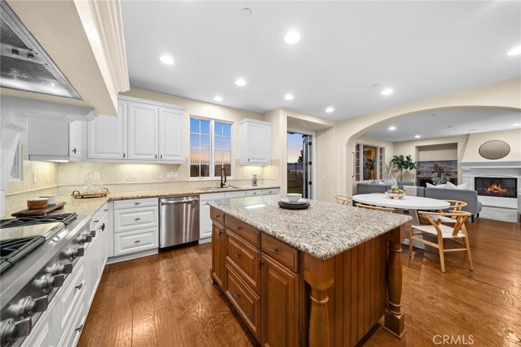46 Silhouette Irvine, CA 92603 - Photo 9 of 42 a kitchen with a stove a sink a kitchen island with a dining table and chairs