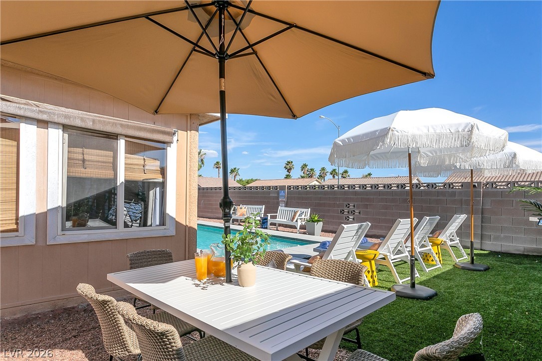 101 Beaver Ridge Avenue North Las Vegas, NV 89031 - Photo 38 of 42 An inviting backyard oasis offers a sparkling pool and a charming patio dining area, perfect for entertaining.