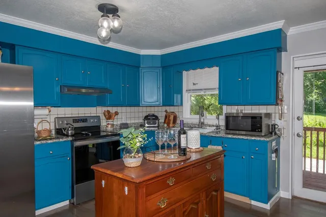 a kitchen with stainless steel appliances granite countertop a stove refrigerator and microwave