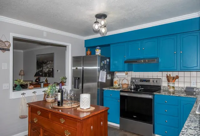 a kitchen with granite countertop stainless steel appliances and wooden cabinets