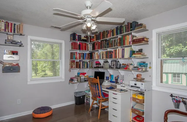 a workspace with furniture bookshelf and a window