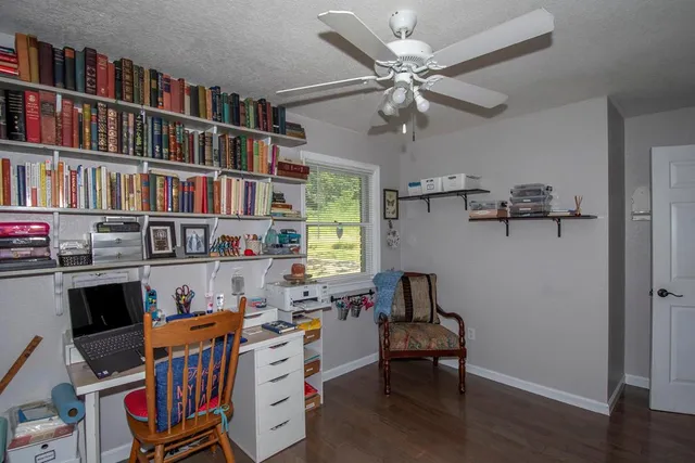 a room with furniture a bookshelf and a window