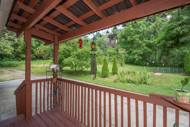 a view of a backyard with large trees and wooden fence