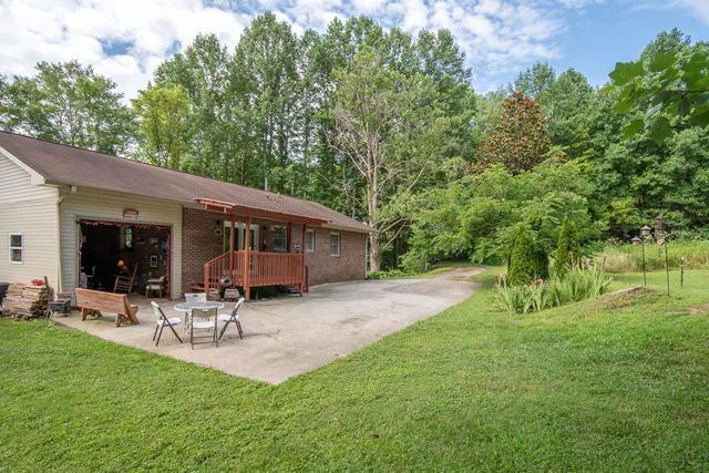 a view of a patio with table and chairs and potted plants with large tree