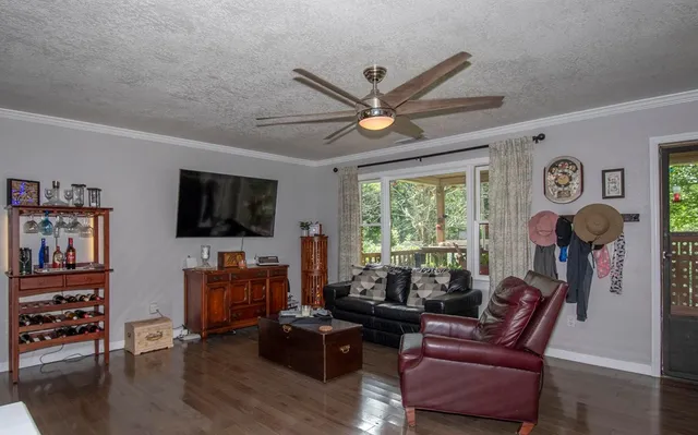 a living room with furniture a window and a flat screen tv