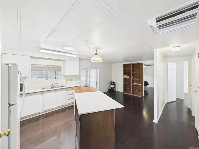a kitchen with stainless steel appliances a dining table chairs and a refrigerator
