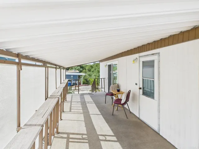 a view of a house with wooden fence next to a yard