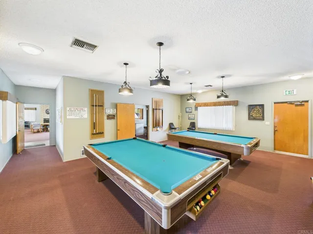 a room with pool table and windows