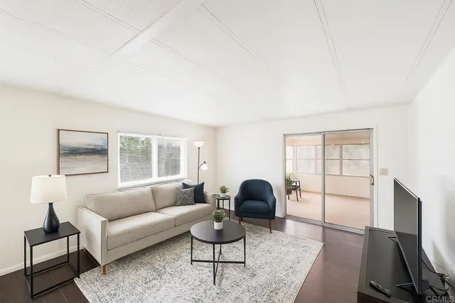 a living room with furniture a window and a flat screen tv