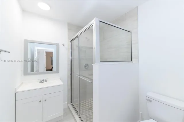 a bathroom with a shower sink and mirror