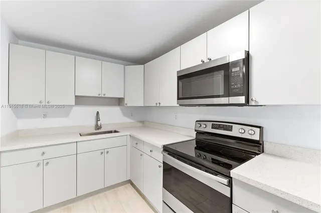 a kitchen with cabinets stainless steel appliances and a sink