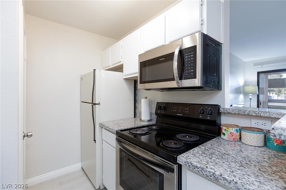 5171 South Lindell Road, Unit 103 Las Vegas, NV 89118 - Photo 12 of 24 A well-equipped kitchen features a stainless steel microwave and granite countertops for effortless meal preparation.