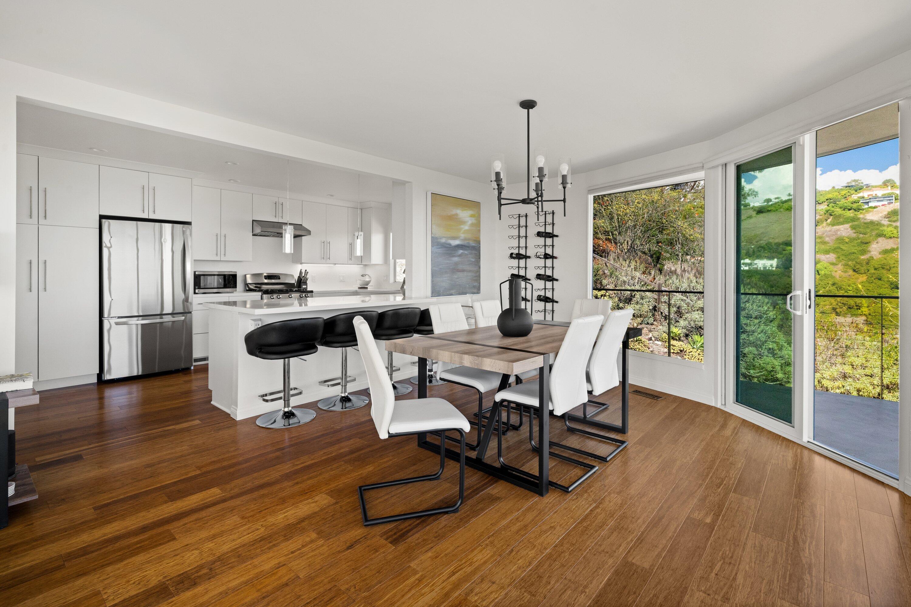 128 Las Alturas Road Santa Barbara, CA 93103 - Photo 12 of 34 a living room with furniture a dining table wooden floor and a floor to ceiling window