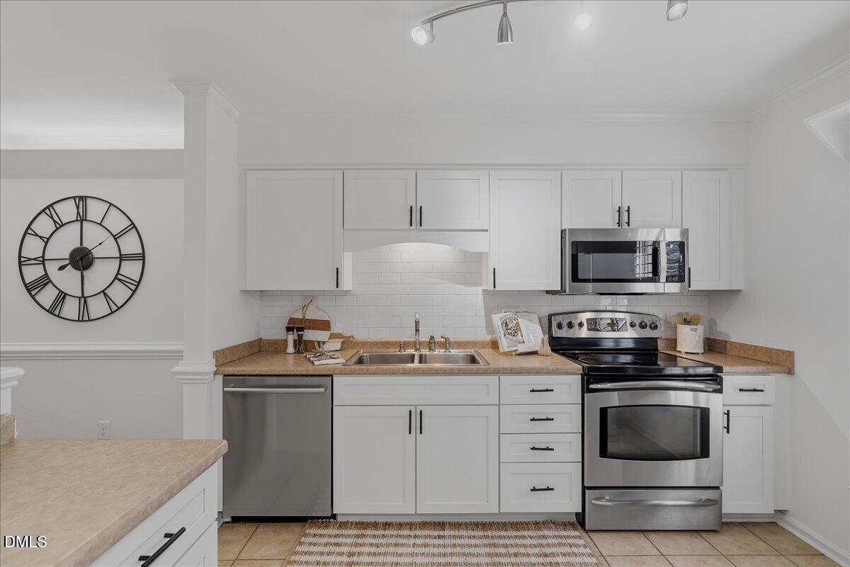 2834 Wayland Drive Raleigh, NC 27608 - Photo 5 of 26 a kitchen with white cabinets stainless steel appliances and sink