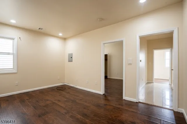 a view of empty room with wooden floor
