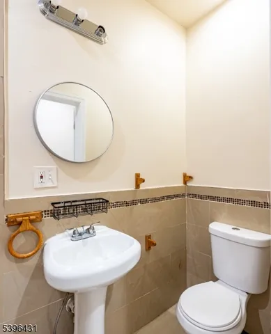 a bathroom with a toilet a sink and a mirror