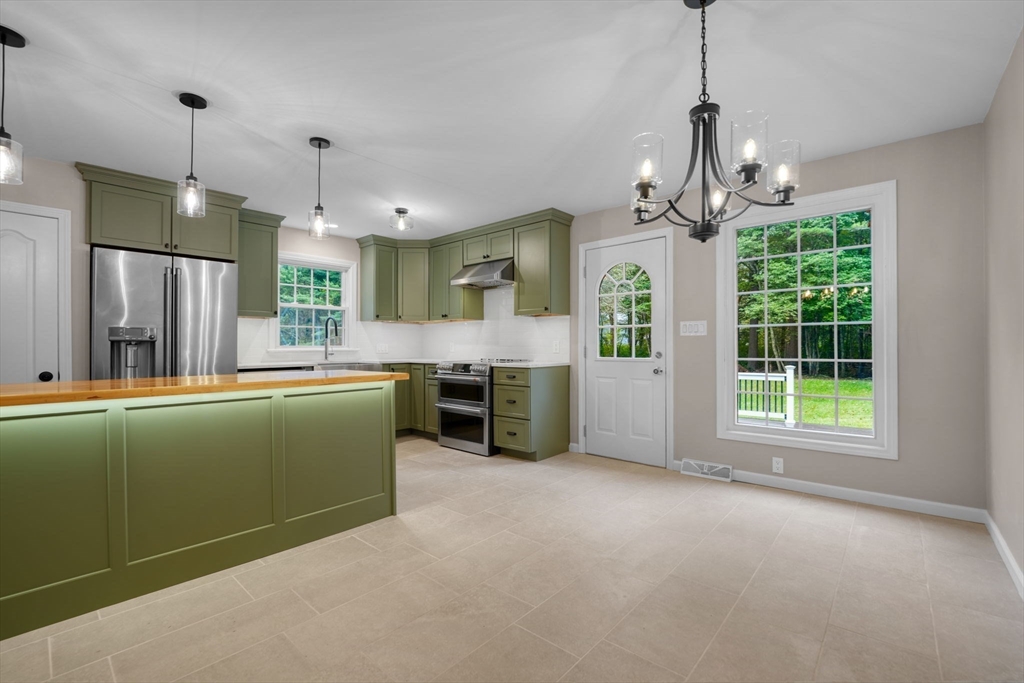 2 Woodland Road Acushnet, MA 02743 - Photo 5 of 26 a view of a kitchen with stainless steel appliances granite countertop cabinets and a chandelier