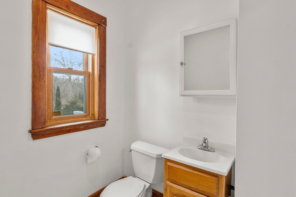 370 R Grove, Unit REAR Boston, MA 02132 - Photo 12 of 21 a bathroom with a toilet sink vanity and mirror