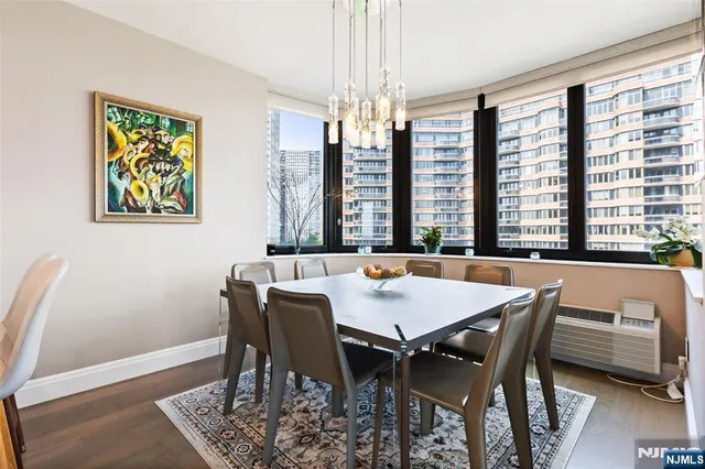 a view of a dining room with furniture a chandelier and wooden floor