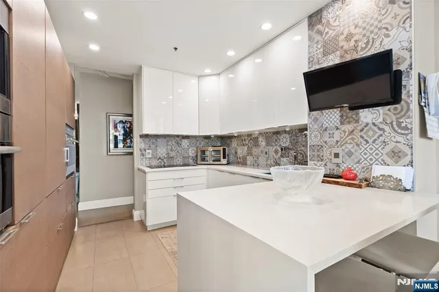a kitchen with stainless steel appliances a microwave a sink and white cabinets
