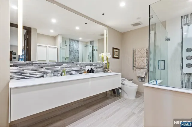 a bathroom with a double vanity sink mirror and toilet