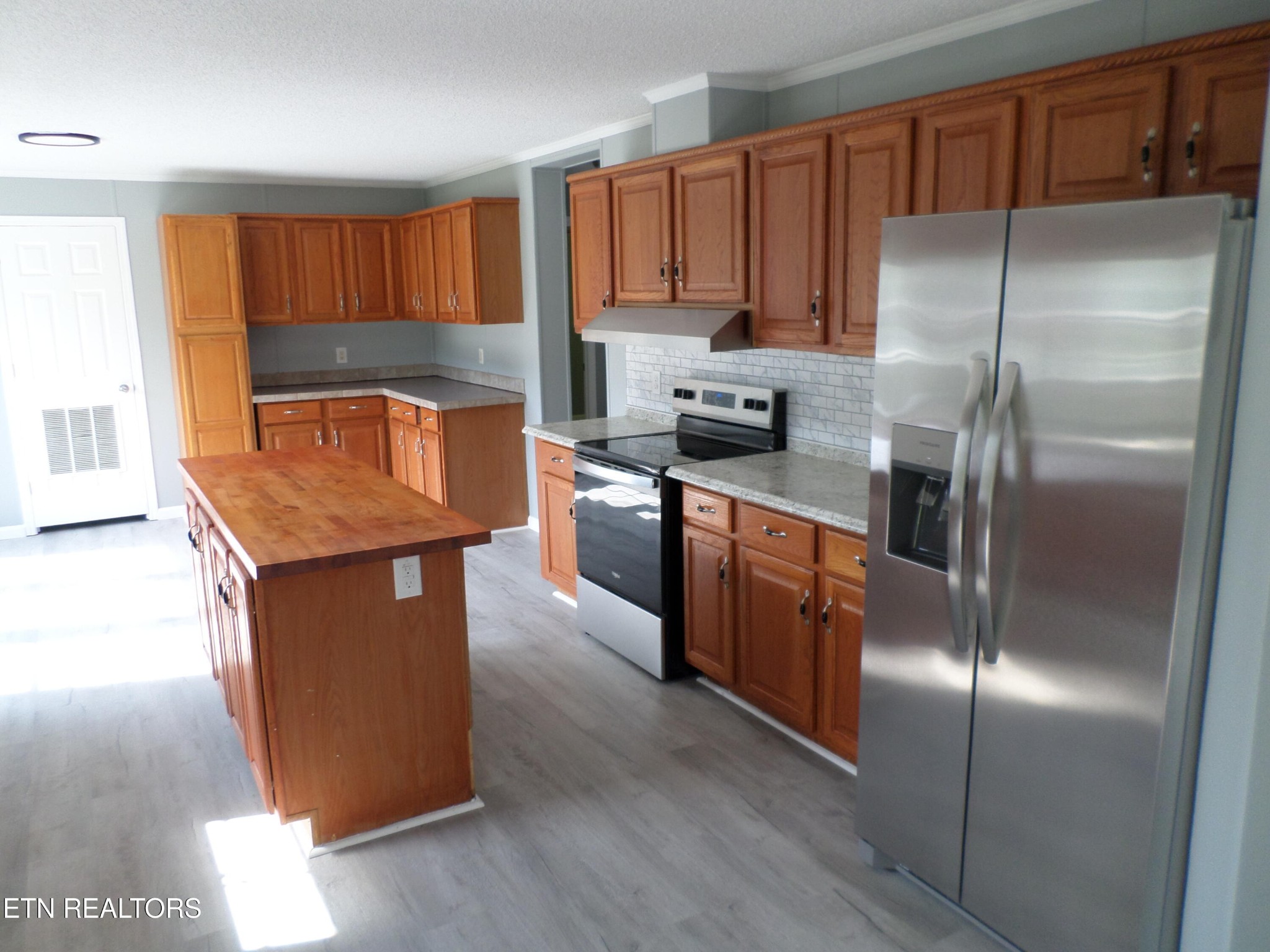 1936 Dripping Springs Road Seymour, TN 37865 - Photo 4 of 13 a kitchen with kitchen island granite countertop wooden cabinets a refrigerator and a sink