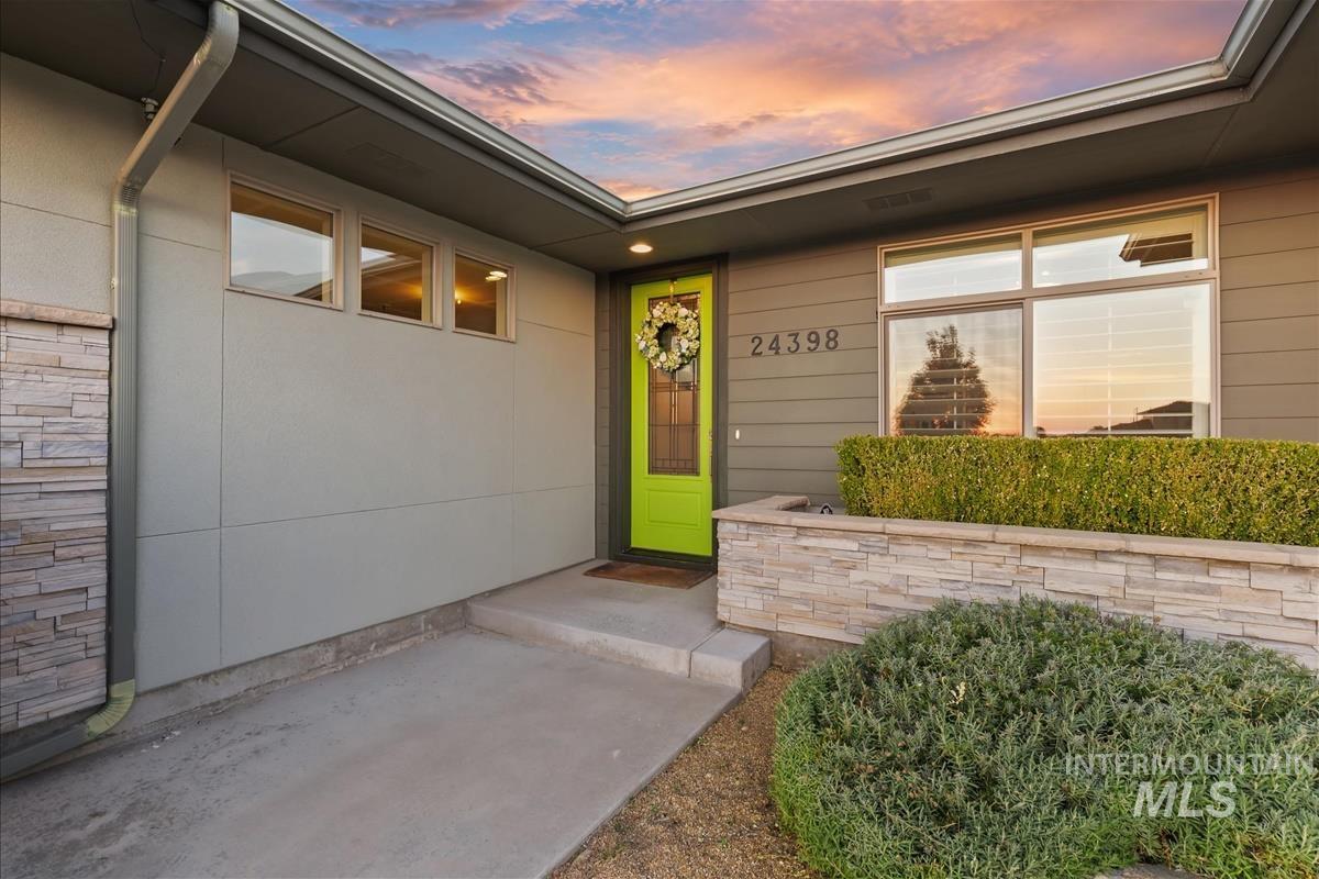24398 Tombstone Ridge Court Middleton, ID 83644 - Photo 41 of 48 Contemporary exterior with horizontal siding, a bright green entry door, and multi-paned windows