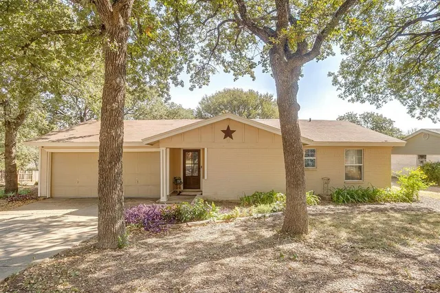 a front view of house with yard and trees around