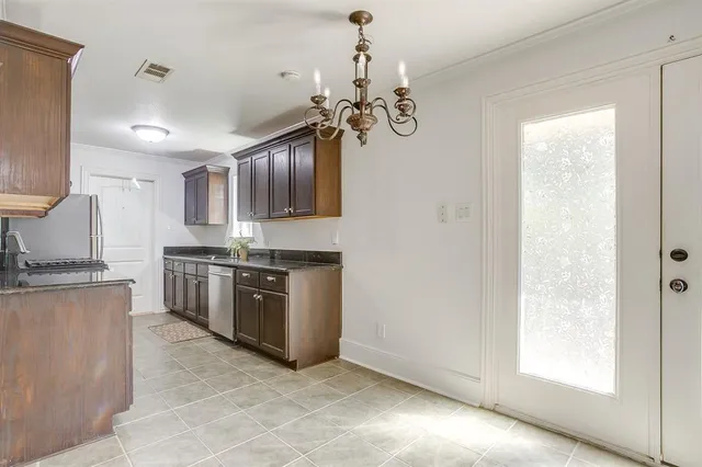 a kitchen with stainless steel appliances granite countertop a stove top oven a sink a counter space and cabinets