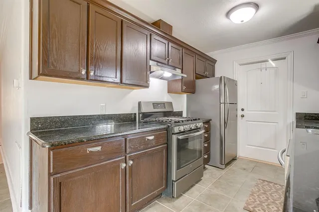 a kitchen with stainless steel appliances granite countertop a refrigerator stove and sink