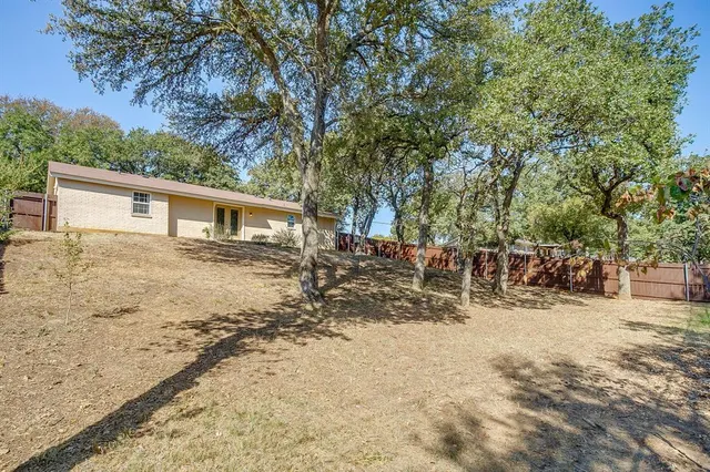 a view of house with backyard and trees
