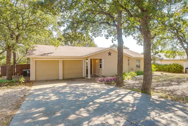 a view of a house with a yard and tree s