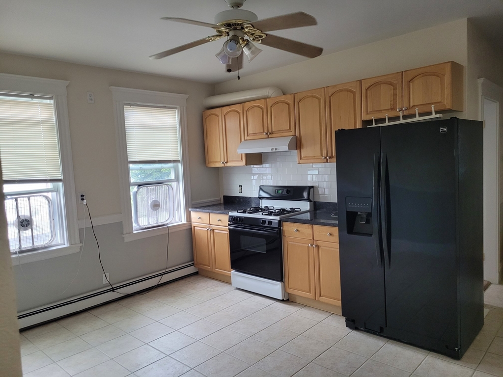39 Irving Street, Unit 4 Everett, MA 02149 - Photo 6 of 8 a kitchen with stainless steel appliances granite countertop a refrigerator and a stove top oven