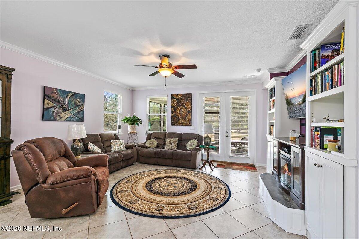 53 Monroe Avenue St. Augustine, FL 32086 - Photo 11 of 26 a living room with furniture a bookshelf and a chandelier