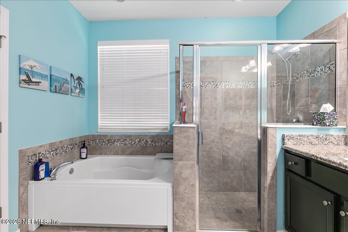 53 Monroe Avenue St. Augustine, FL 32086 - Photo 17 of 26 a bathroom with a granite countertop sink and a bathtub