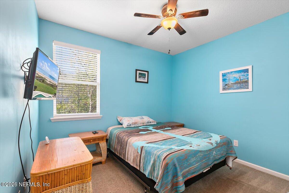 53 Monroe Avenue St. Augustine, FL 32086 - Photo 19 of 26 a bedroom with a bed and a chandelier