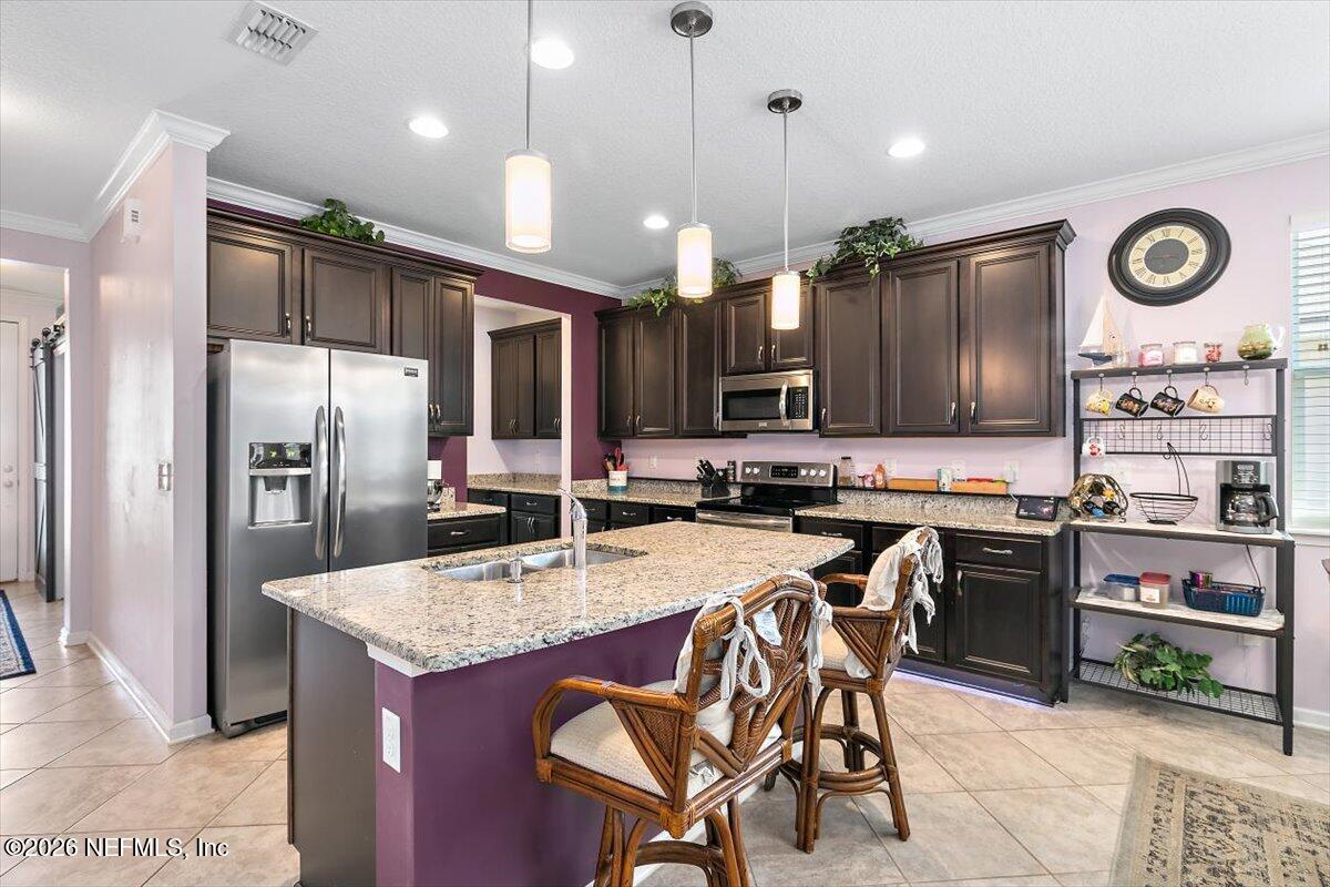 53 Monroe Avenue St. Augustine, FL 32086 - Photo 6 of 26 a kitchen with stainless steel appliances granite countertop a stove refrigerator and cabinets