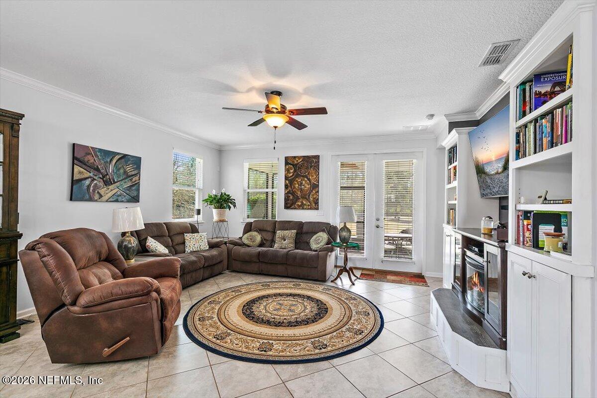 53 Monroe Avenue St. Augustine, FL 32086 - Photo 10 of 26 a living room with furniture a bookshelf and a chandelier