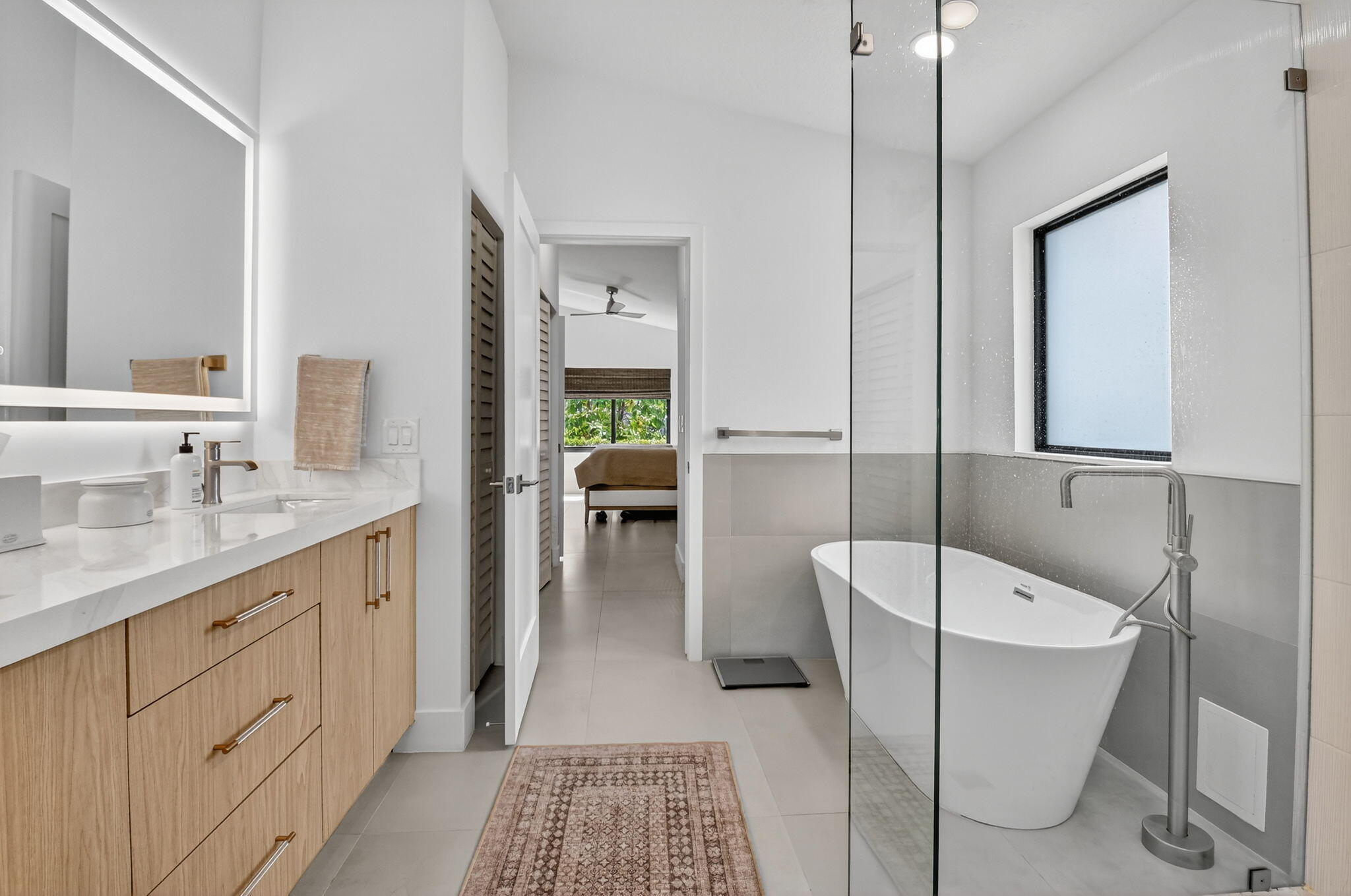 1175 Sea Grape Circle Delray Beach, FL 33445 - Photo 33 of 64 a spacious bathroom with a double vanity sink a mirror and a bathtub