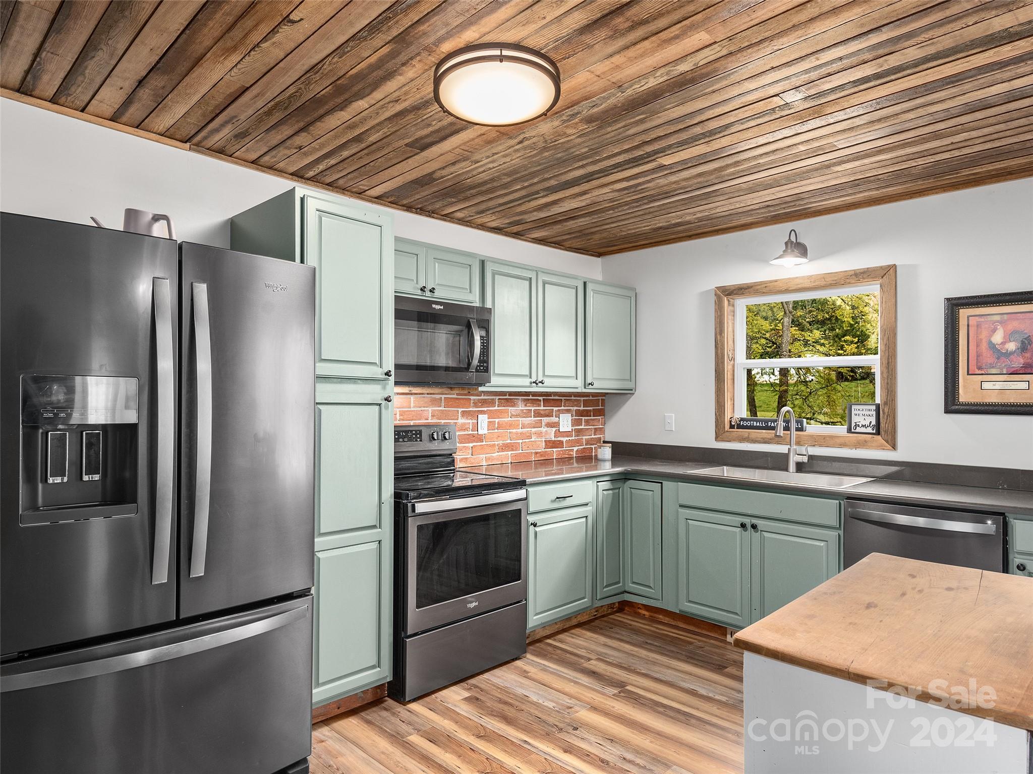 1426 Poison Cove Road Clyde, NC 28721 - Photo 7 of 12 a kitchen with stainless steel appliances granite countertop a sink stove and refrigerator