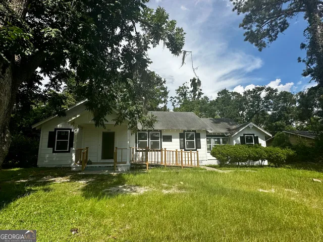 a front view of a house with a yard table and chairs