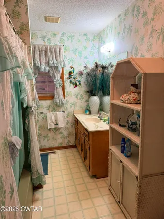a bathroom with a sink mirror and a shower