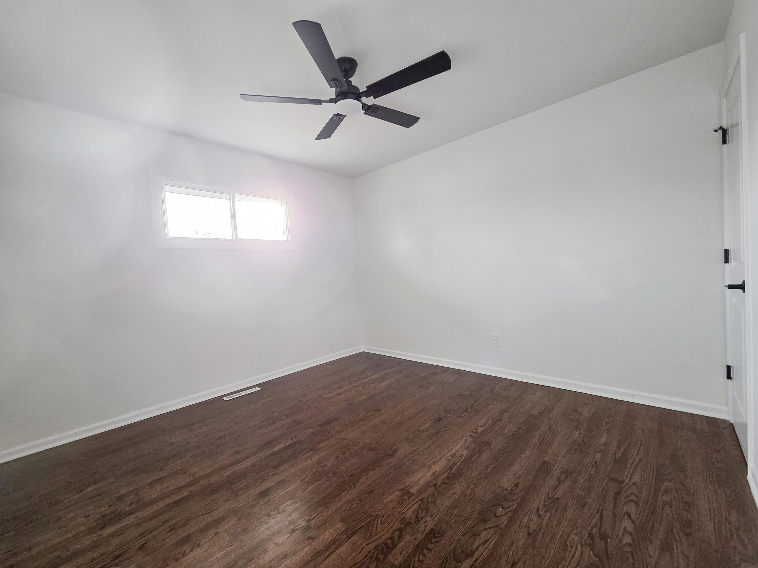 1629 Tennessee Street Gary, IN 46407 - Photo 13 of 26 an empty room with wooden floor ceiling fan and windows